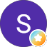 A purple circle with a white letter S in the center. In the lower right corner, there is a small circle with a blue border and a white star inside.